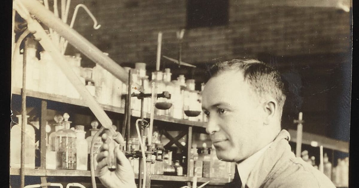 A chemist working with glassware at a laboratory bench