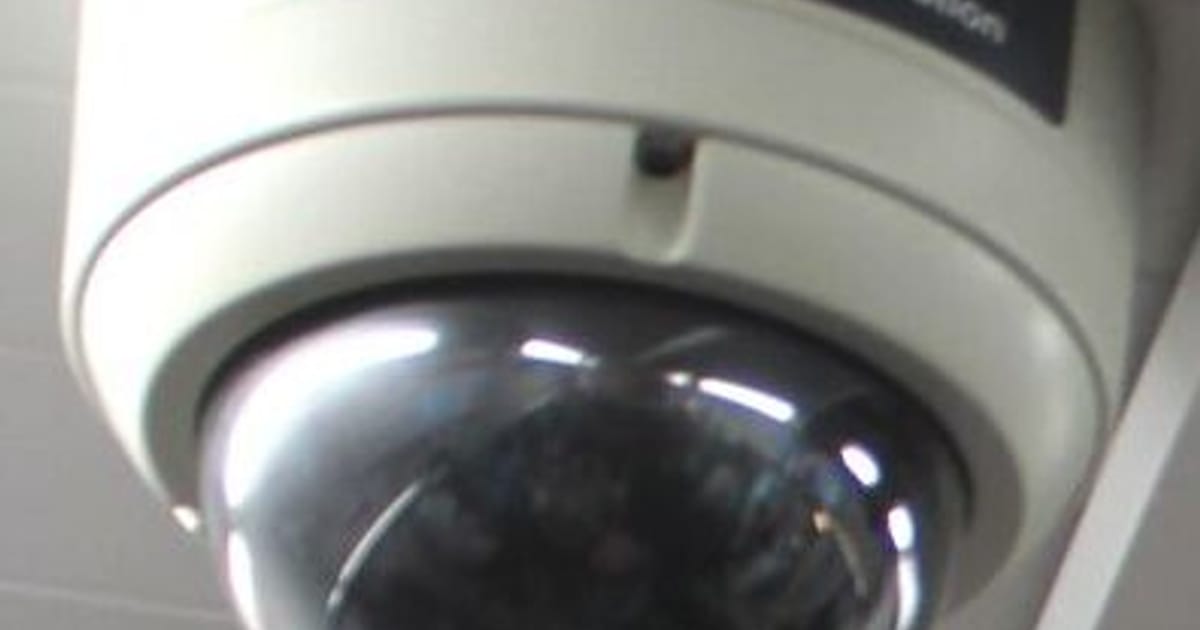 A white dome surveillance camera mounted on a ceiling