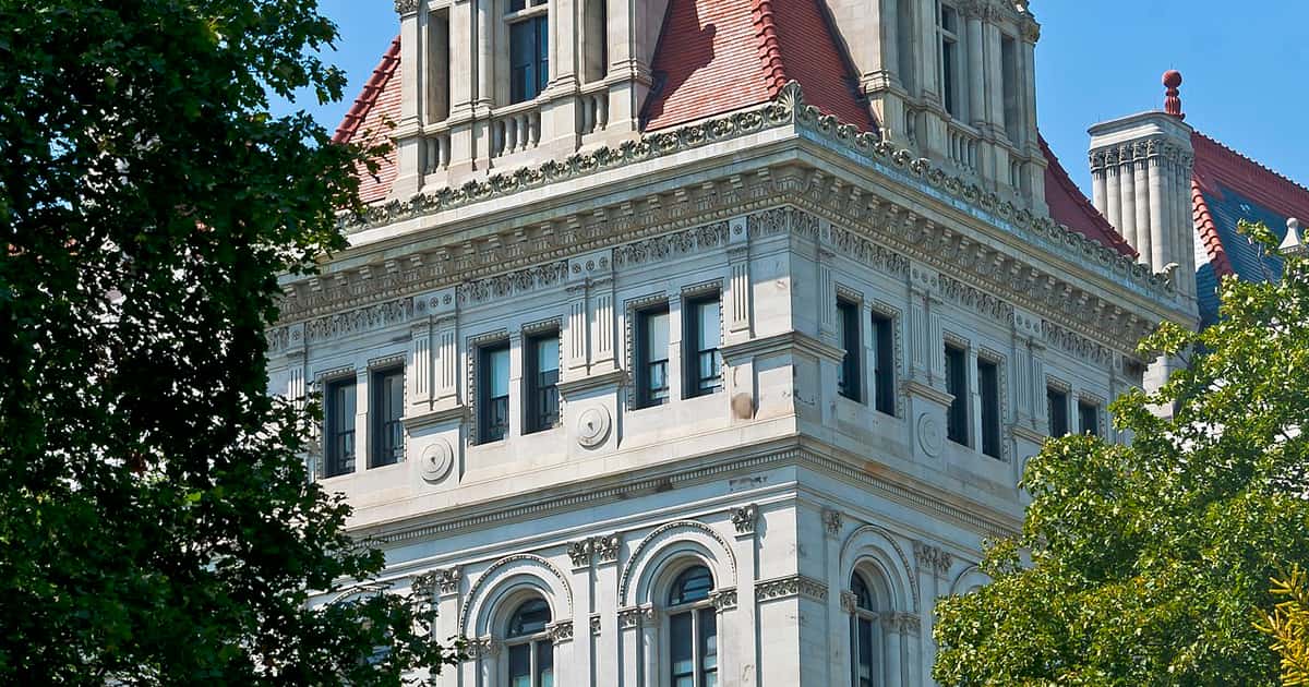 A tower of the New York State Capitol in Albany framed by trees